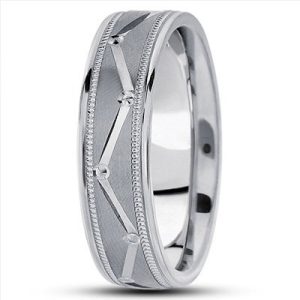 A silver ring with a textured design and small decorative elements is displayed on a light background.