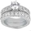A silver wedding ring set featuring a central round diamond surrounded by smaller diamonds in a decorative band.