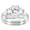 A silver engagement ring features a large round center diamond surrounded by smaller rectangular and round diamonds.