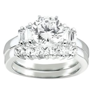 A silver engagement ring features a large round center diamond surrounded by smaller rectangular and round diamonds.
