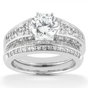 A diamond engagement ring set features a round center stone surrounded by smaller diamonds on a silver band.