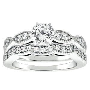 A silver engagement ring set features a central round diamond with additional smaller diamonds along the band.