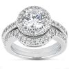 A silver engagement ring features a large round center stone surrounded by smaller stones on the band.