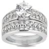 A silver engagement ring features a large central diamond surrounded by smaller stones set in two rows.