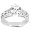 A silver ring with a large round diamond in the center and smaller diamonds set in a row along the band.