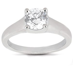 A silver ring features a large, round, clear diamond set in a four-prong setting.