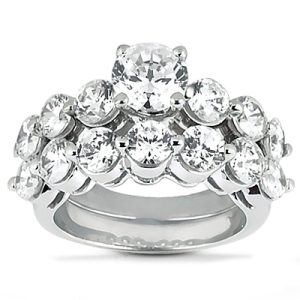 A close-up view of a multi-tiered diamond engagement ring featuring a central round stone surrounded by smaller round stones on a silver band.
