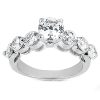 A silver engagement ring features a large central round diamond surrounded by smaller diamonds in a curved setting.