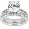 A silver engagement ring features a large central round diamond and a band adorned with smaller diamonds.