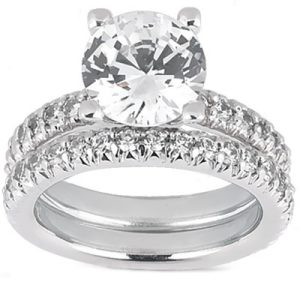 A silver engagement ring features a large central round diamond and a band adorned with smaller diamonds.