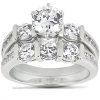 A silver engagement ring features a large round diamond at the center, surrounded by smaller diamonds on the band.