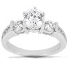 Three-stone engagement ring featuring a large, round central diamond flanked by two smaller round diamonds on a polished white metal band.