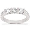 A silver ring features three prominently displayed round diamonds set in a row, accompanied by smaller stones along the band.
