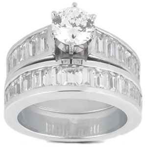A silver engagement ring and wedding band set features a central round diamond surrounded by baguette-cut diamonds.
