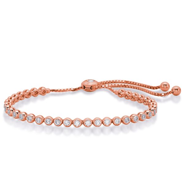 A rose gold bracelet with circular stones and an adjustable sliding closure is displayed on a white background.