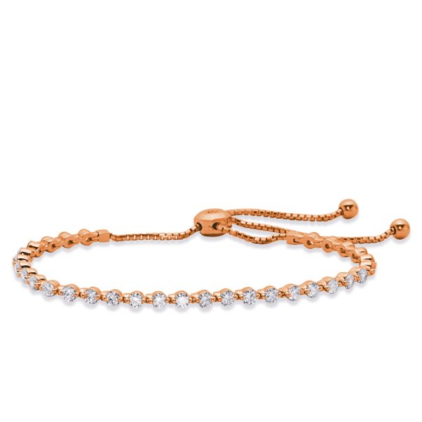A rose gold bracelet with a sliding adjustable clasp features a row of sparkling clear stones.