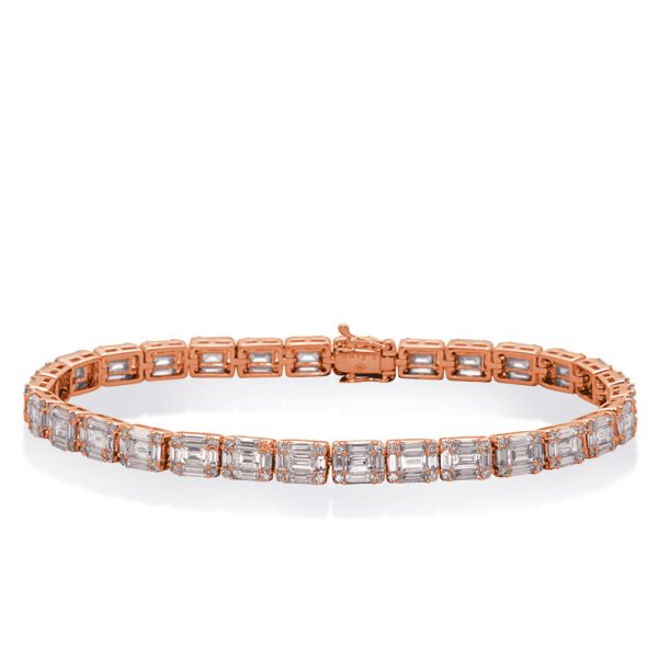 A rose gold bracelet with rectangular clear stones is displayed flat on a surface.