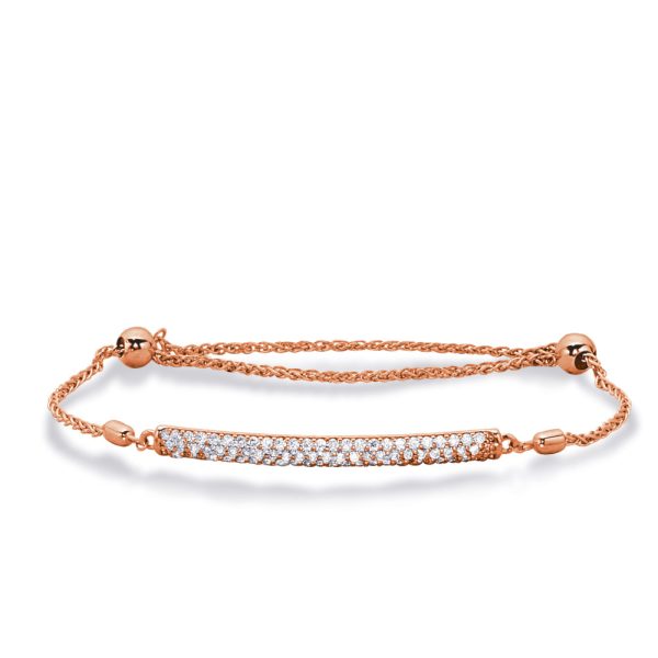 A rose gold bracelet features a slender, embellished bar with a row of clear stones.