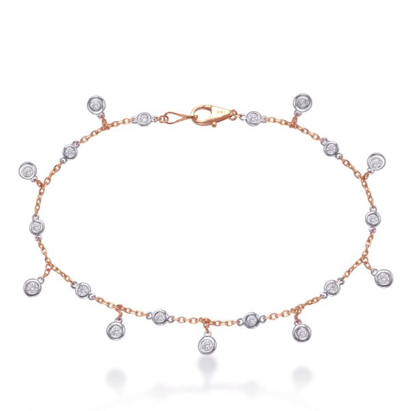 A delicate bracelet with circular silver and gold charms is displayed against a white background.
