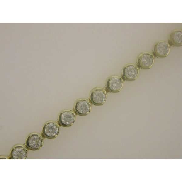 A gold bracelet featuring several round clear stones arranged in a linear pattern.