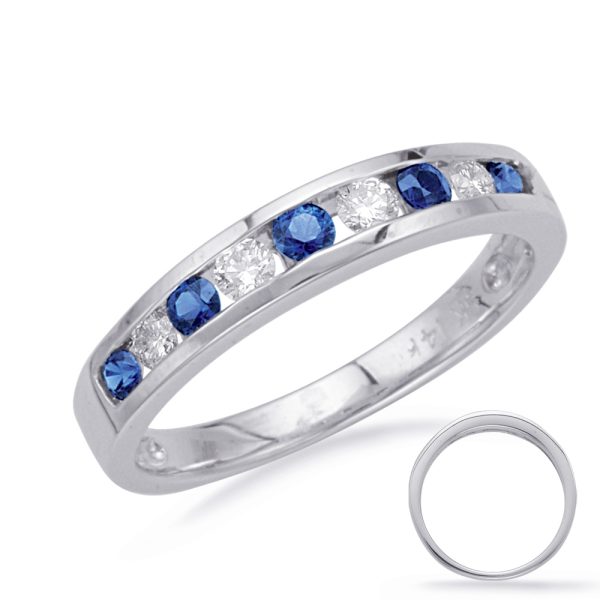 A silver band ring features alternating blue and clear gemstones set in a row along the top.
