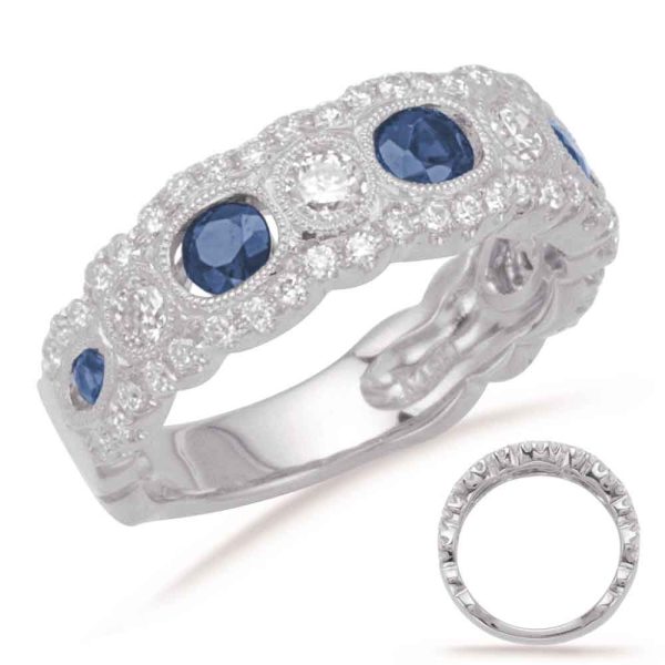 A silver ring with blue and clear gemstones is displayed, showcasing an intricate design.