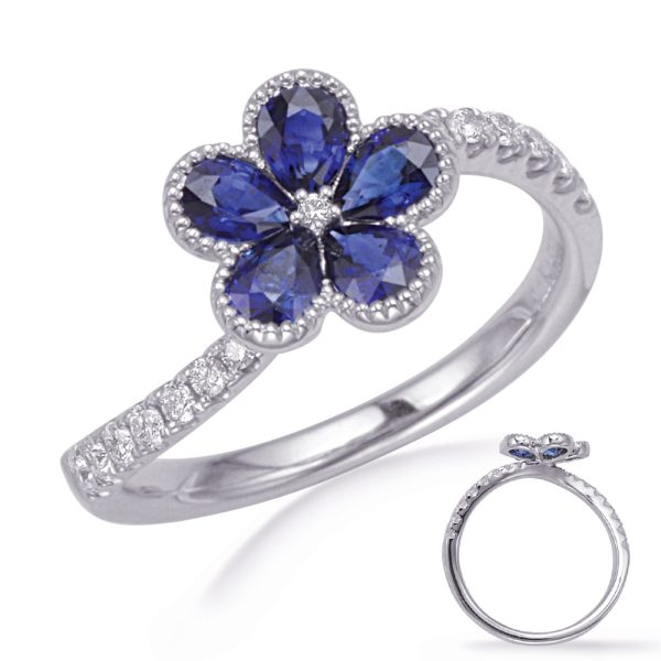 Silver ring featuring a flower design with blue gemstones and a row of small diamonds on the band.
