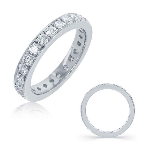A silver band ring adorned with multiple clear gemstones is positioned beside a flat, simple ring.