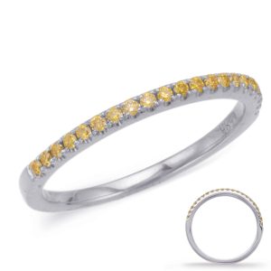 A silver ring with a row of yellow gemstones is displayed from a slight angle, showcasing its circular shape and sparkling details.