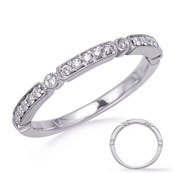 A silver ring with a row of small, sparkling diamonds is shown from the side, emphasizing its delicate design.