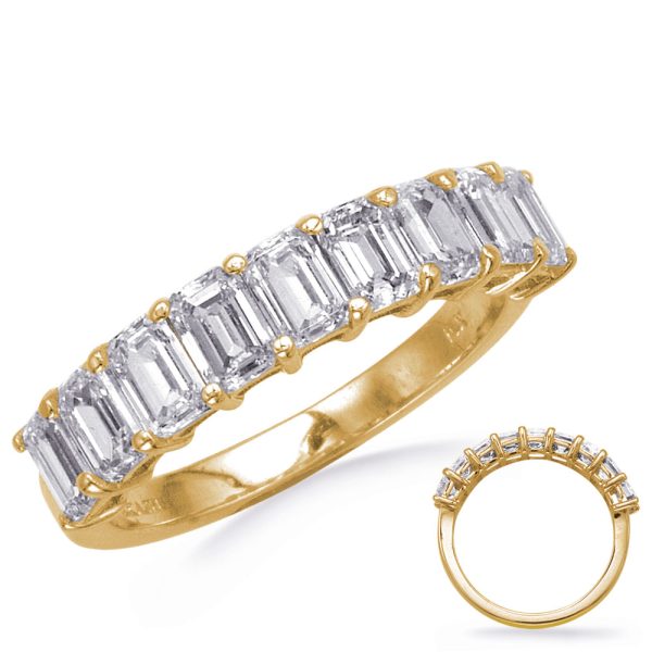 A gold band ring features a series of rectangular, clear gemstones set in a linear arrangement.