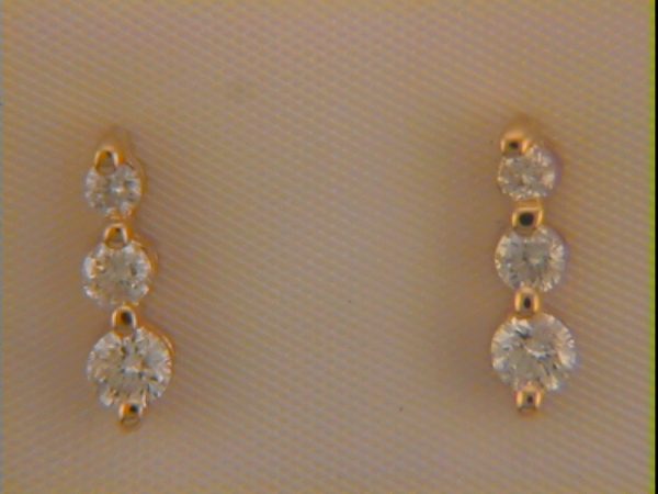 Gold earrings with three round gemstones arranged vertically on each piece.
