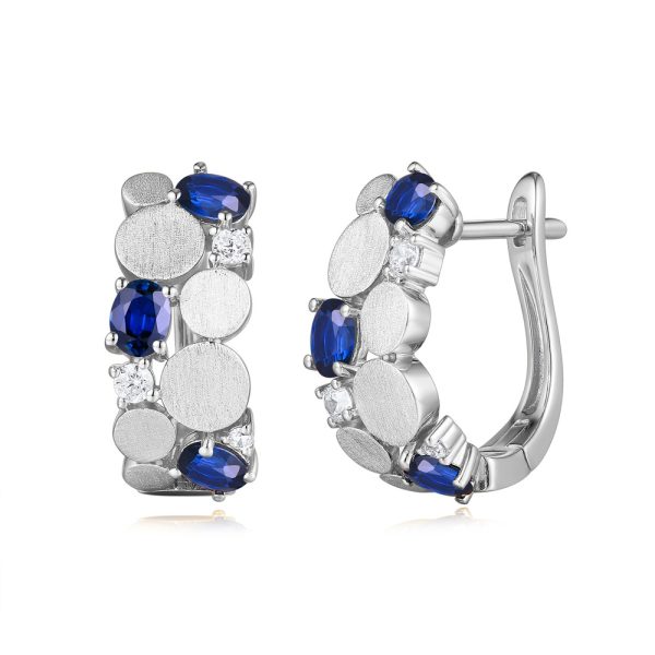 Silver hoop earrings adorned with blue and clear gemstones.