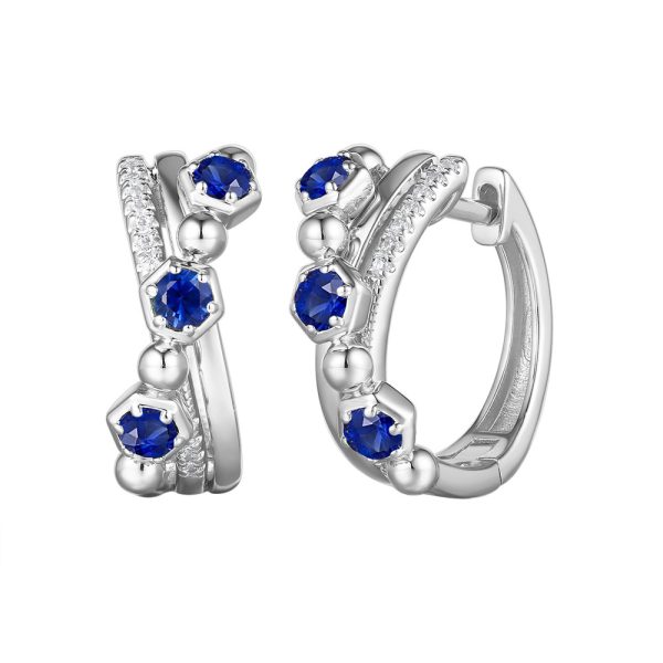 Silver hoop earrings adorned with blue gemstones and small decorative elements.