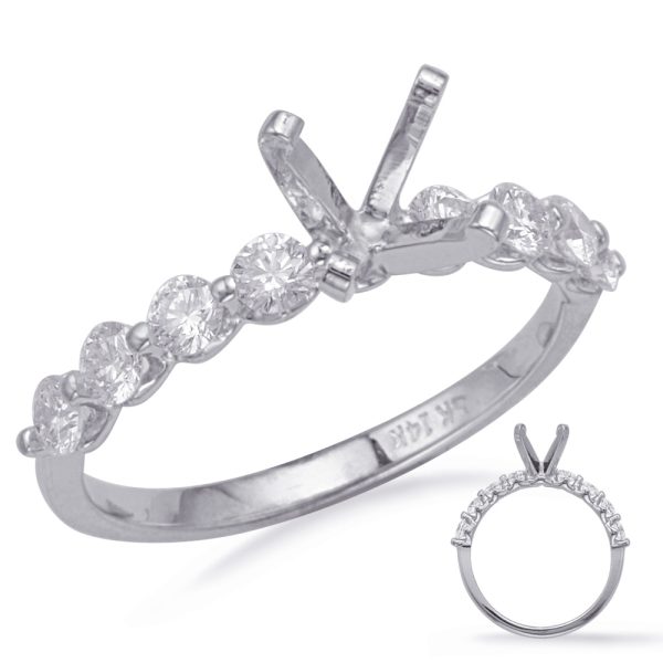 A silver ring with multiple round diamonds is displayed at an angle, showcasing its setting and craftsmanship.