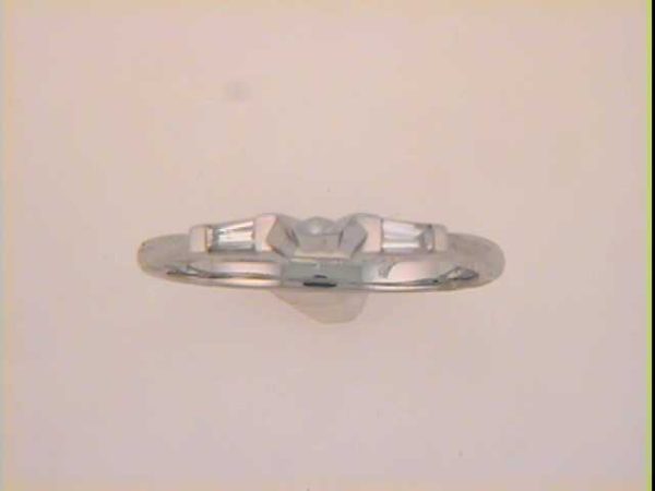 A silver ring with an intricate design is displayed against a light-colored background.