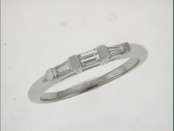 A silver ring with three rectangular gemstones is positioned upright against a light background.