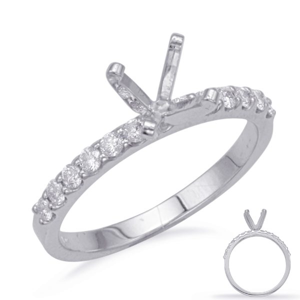 A silver ring with a diamond-encrusted band and a four-prong setting is displayed prominently.