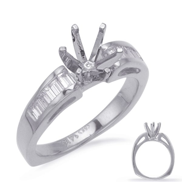 Silver engagement ring featuring a central prong setting and baguette cut stones along the band.