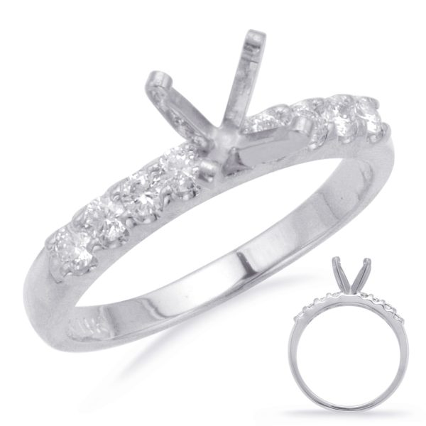 A silver ring with a row of small clear stones and a raised prong setting is displayed against a white background.