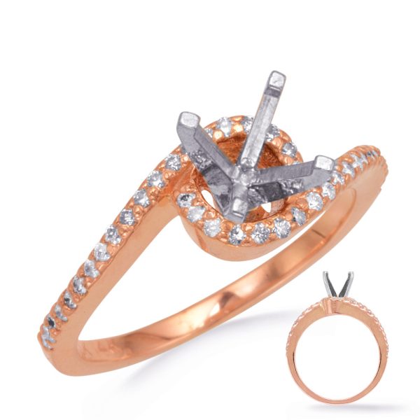 A rose gold engagement ring with small diamonds features a silver prong setting for a central stone.