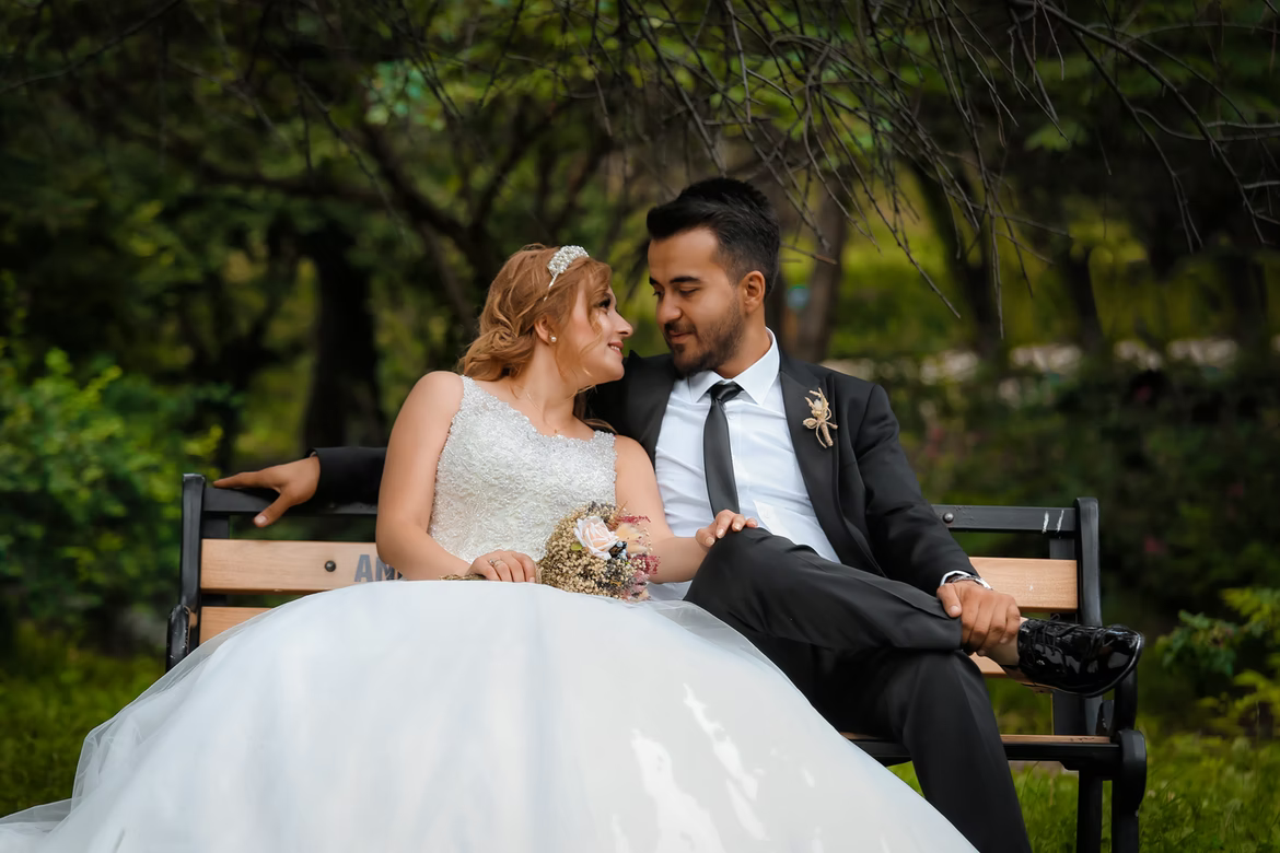 A bride and groom sitting on a bench