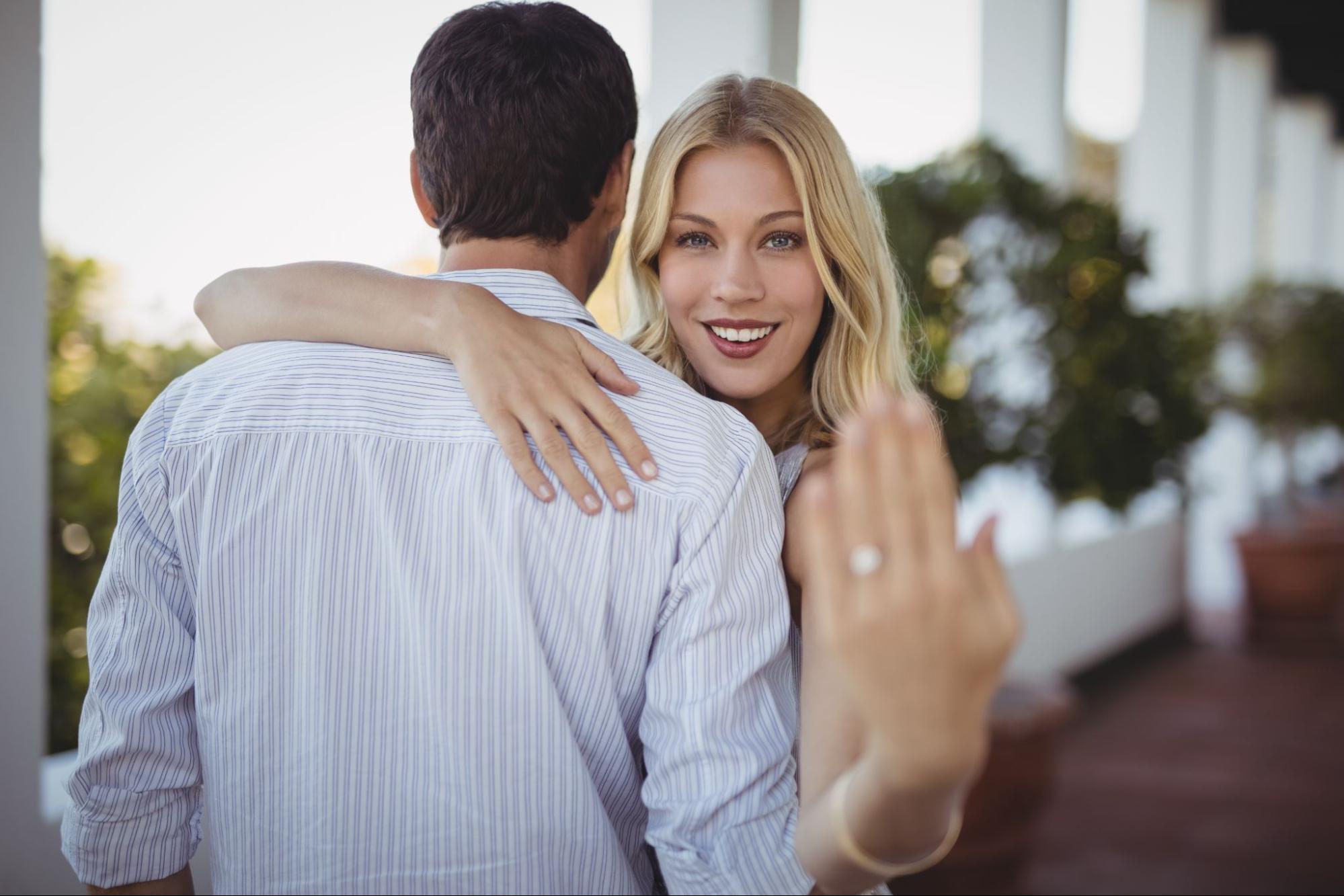 A woman holding up her engagement ring