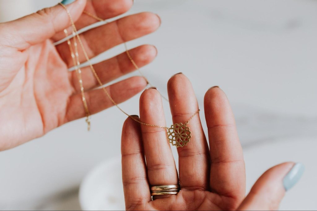Hands holding a gold necklace